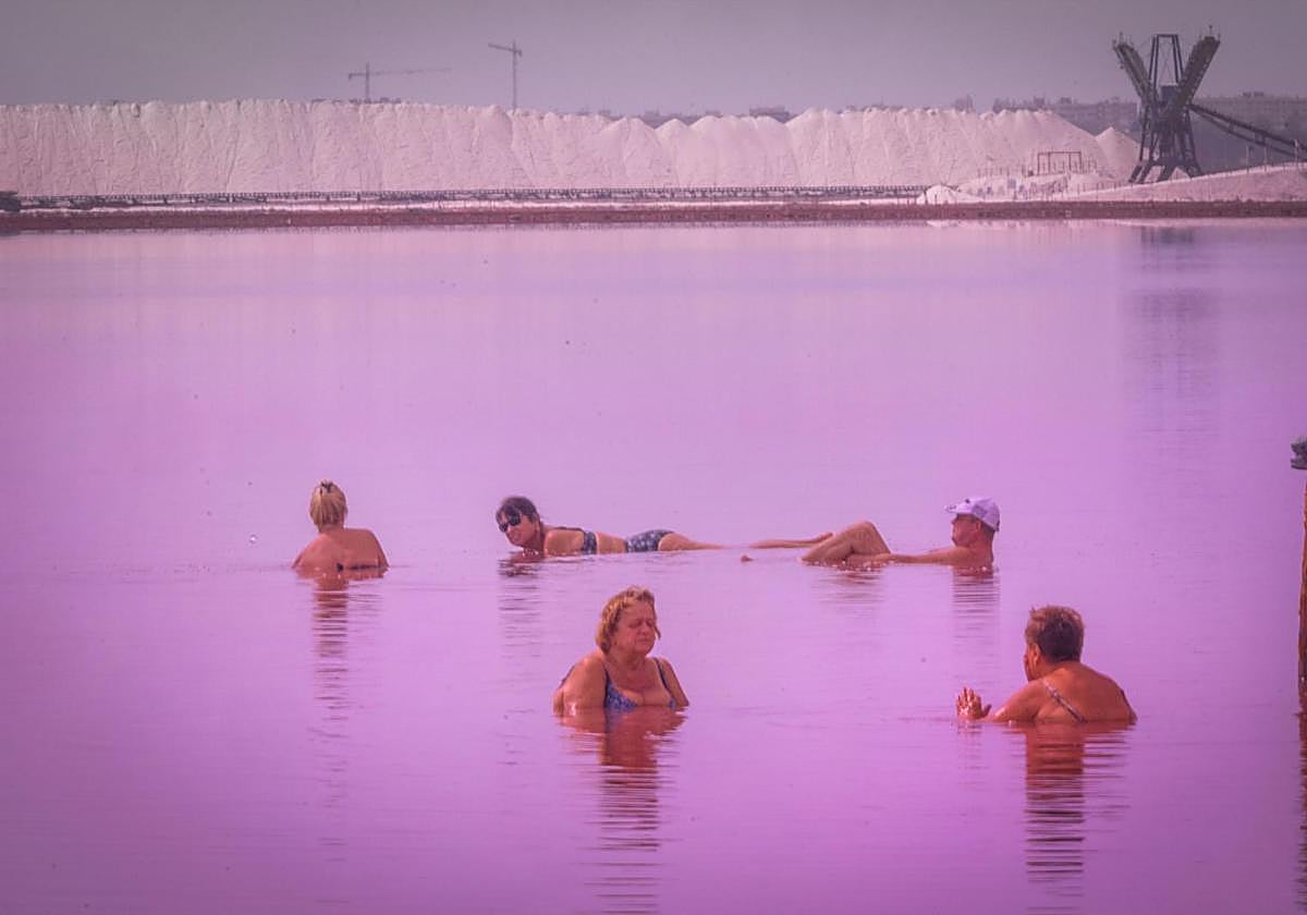 Los turistas toman las orillas de la Laguna Rosa de Torrevieja pese a la prohibición al baño