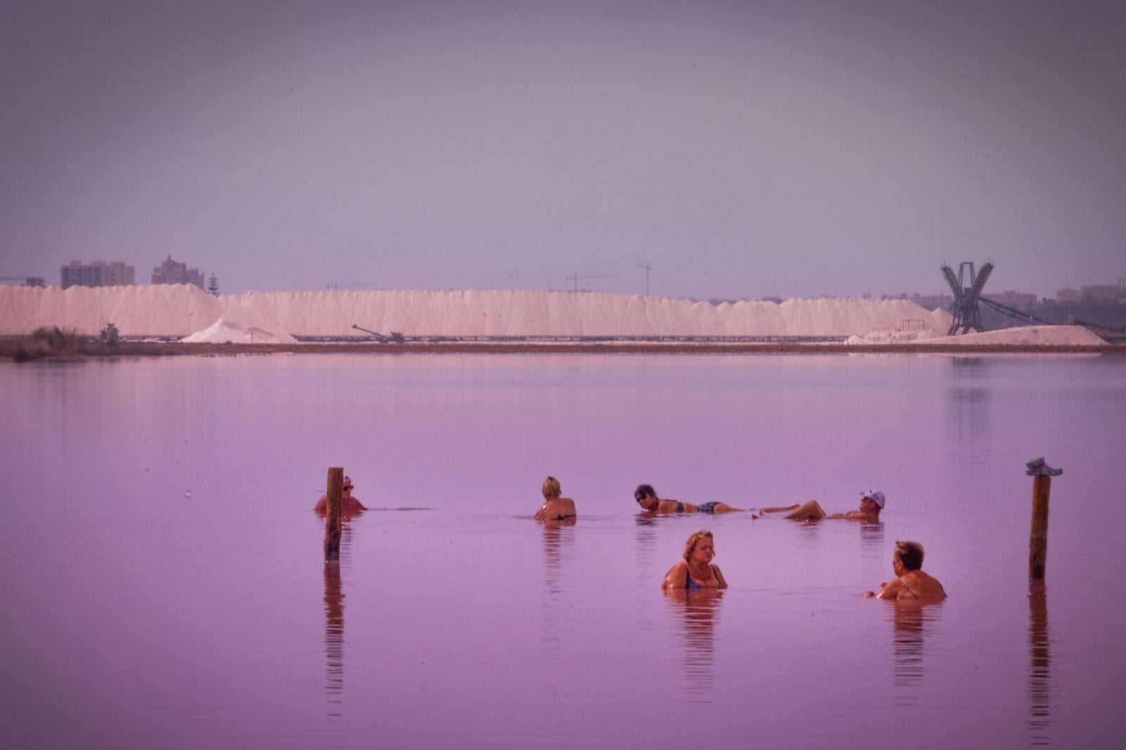 Los turistas toman las orillas de la Laguna Rosa de Torrevieja pese a la prohibición al baño