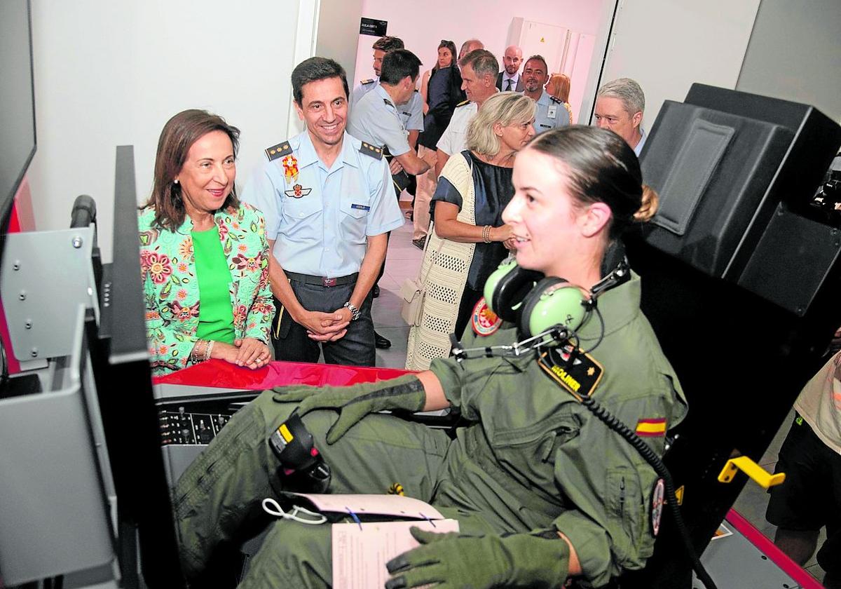 La ministra Margarita Robles habla con una alumna, a los mandos de un simulador de vuelo.