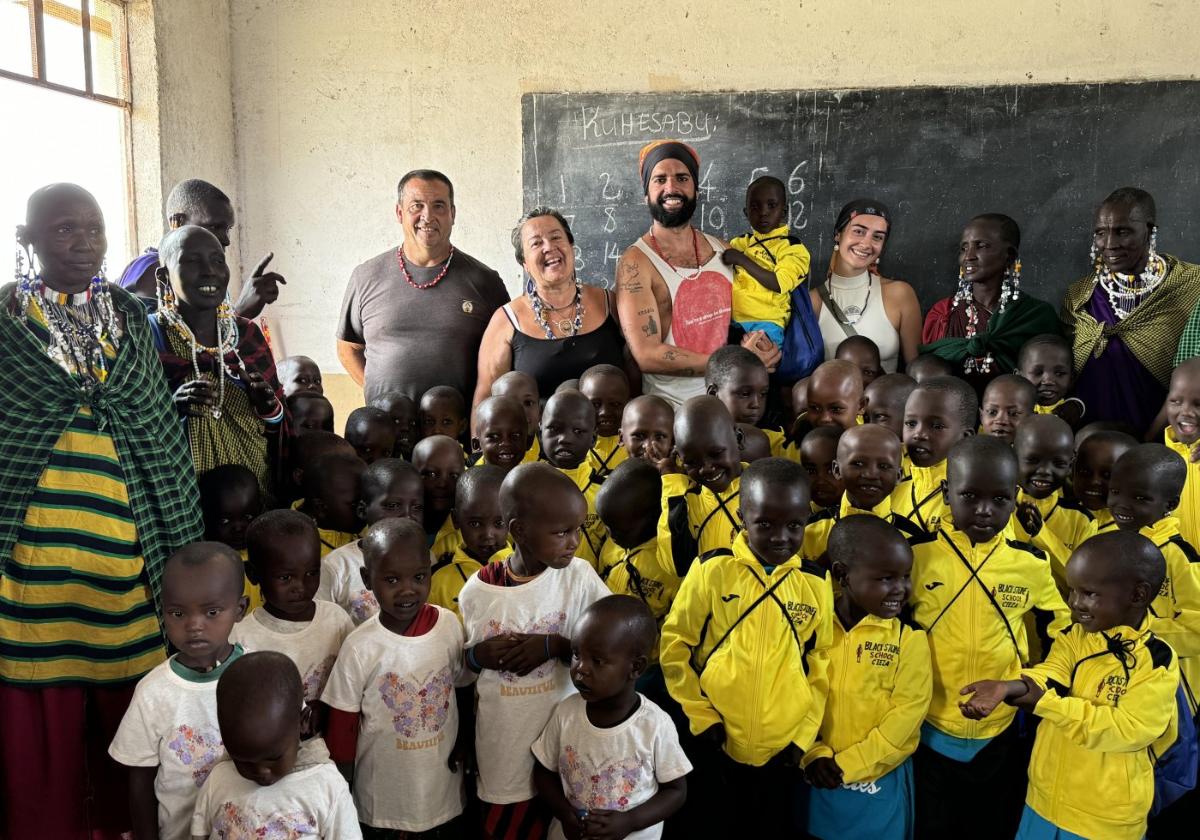 Samuel, con un pequeño en brazos, posa junto a su madre, Silvia Rodríguez, otros voluntarios, los alumnos y parte de la comunidad de Black Stone.