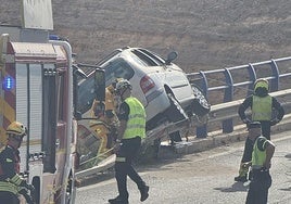 Posición en la que ha quedado el coche, tendido sobre el vallado del puente y escasos centímetros de precipitarse sobre la autovía.