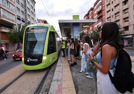 Un grupo de estudiantes toma el tranvía junto a la plaza Circular de Murcia, ayer a mediodía.