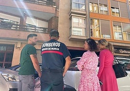 Los bomberos junto a la concejala de Sanidad, Belén Díaz, y la veterinaria municipal, María Dolores Parra, frente al bloque de viviendas donde está atrapado el animal.