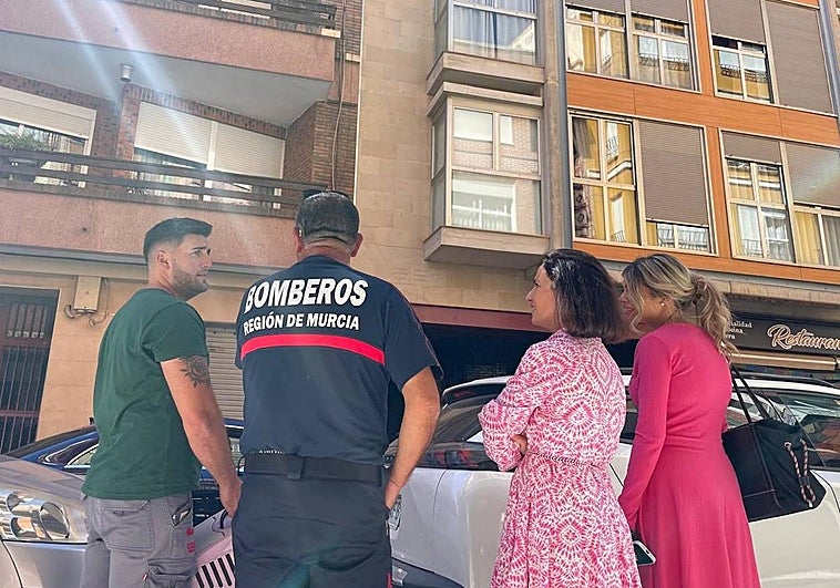Los bomberos junto a la concejala de Sanidad, Belén Díaz, y la veterinaria municipal, María Dolores Parra, frente al bloque de viviendas donde está atrapado el animal.