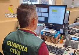Un agente de la Guardia Civil mira los archivos de la investigación.