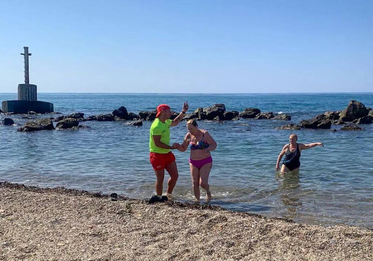 Un socorrista pide a los bañistas que salgan del agua en la playa de Poniente, en Águilas.