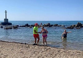 Un socorrista pide a los bañistas que salgan del agua en la playa de Poniente, en Águilas.