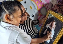 Celeste mira un retrato de su madre Orfilia junto a su abuela Milagros en su casa de Nicaragua.