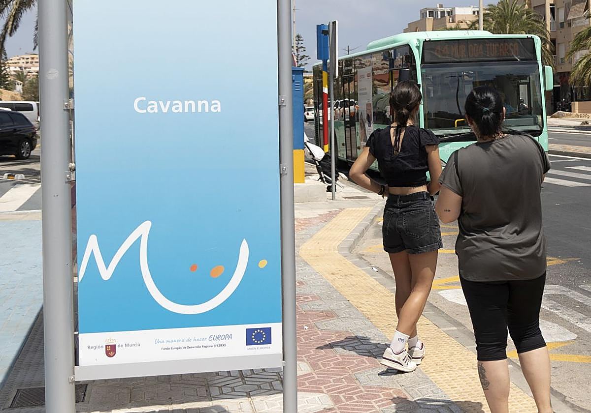 Dos mujeres esperan el autobús en la plaza del Cavanna en La Manga, este verano.