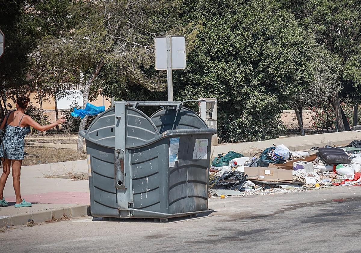 Una vecina deposita basura en un contenedor de la costa.