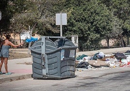 Una vecina deposita basura en un contenedor de la costa.