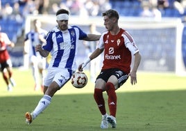 Antonio Toral, jugador del Real Murcia, juega un balón ante Dani Perejón, del Recreativo.