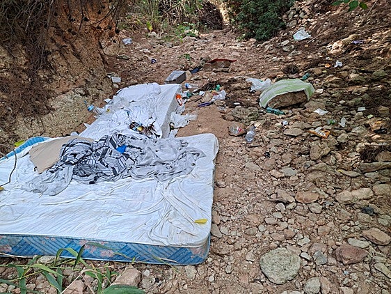 Colchones y residuos abandonados en la rambla de las Estacas, en Orihuela Costa.