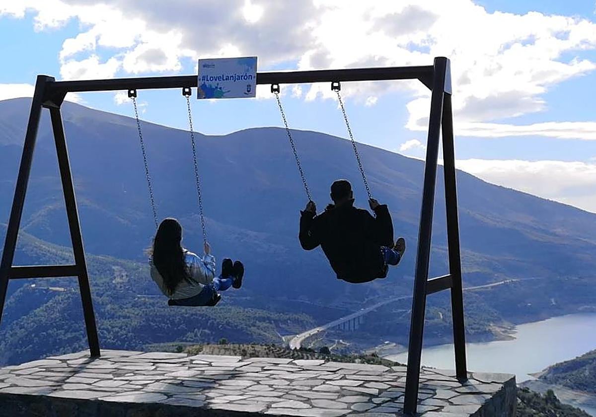 Un hombre y una joven se balancean en un columpio, en una foto de archivo.