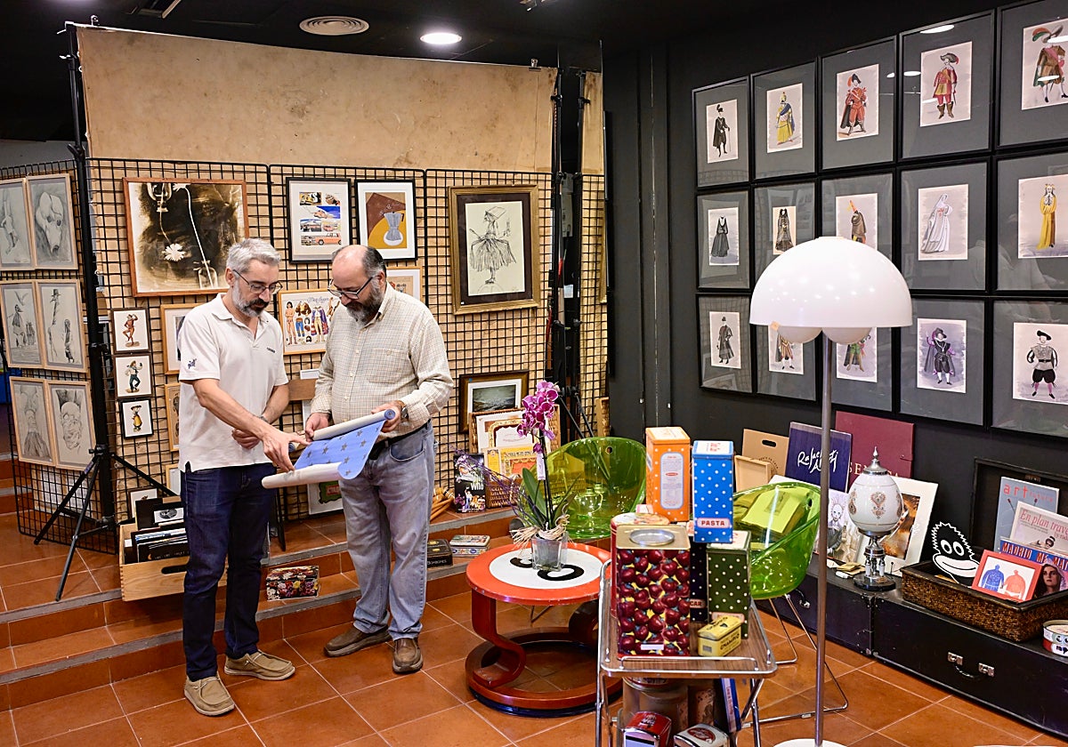 José Carlos Nievas, a la derecha, muestra a Rubén Caral un papel de forrar armarios del siglo XIX.