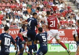 Kike Cadete, jugador del Real Murcia, remata ante Carrasco y Acosta, del Marbella.