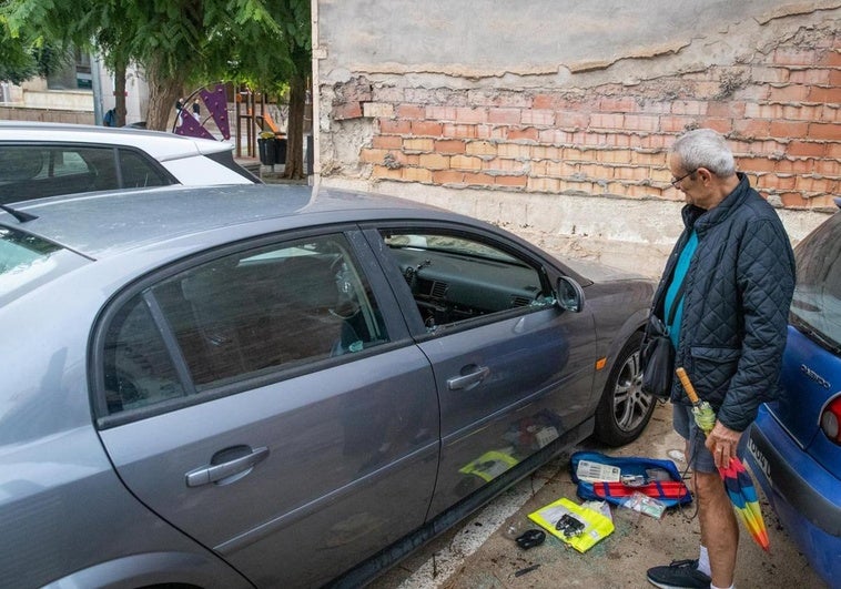 Uno de los afectados por los robos observa el estado en el que ha quedado su coche.