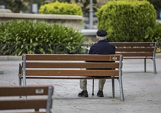 Un anciano sentado en un parque.
