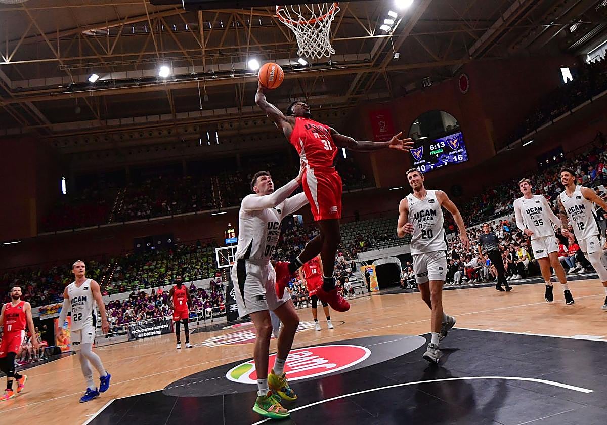 El jugador del UCAM, Dylan Ennis, tira a canasta durante el Partido del Recreo en el Palacio de los Deportes.