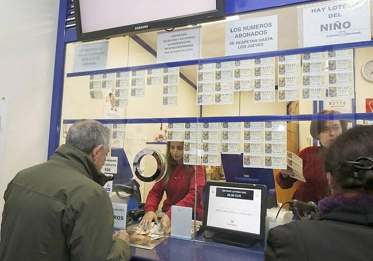 Dos personas compran un décimo de la Lotería del Niño, en una imagen de archivo.
