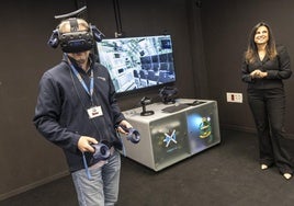 Uno de los ingenieros visita virtualmente la sala de control de un S-80, que aparece en la pantalla; a la derecha, Cristina Abad.