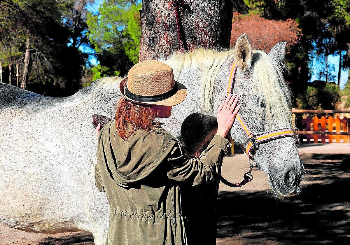 Marina acaricia a una de las yeguas del centro ecuestre de El Valle.