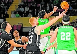 El pívot francés Thomas Smallwood intenta evitar la bandeja del verdiblanco Hughes, este domingo, en el Palacio de Deportes de San Pablo, en Sevilla.