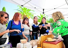 Varios alumnos prueban alimentos sostenibles en la feria.