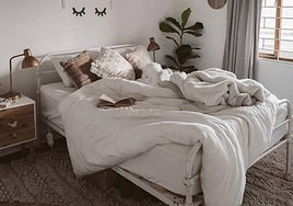 Imagen de una cama con edredón y mantas.