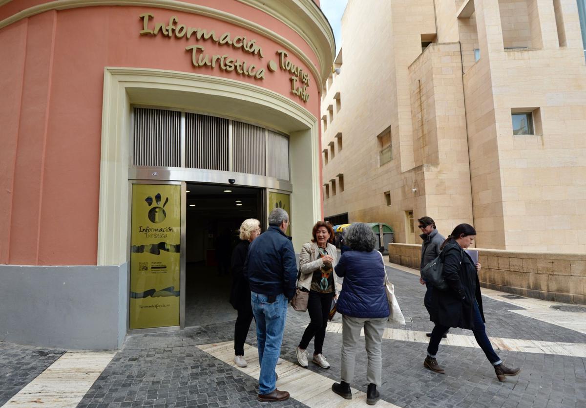 Visitantes a las puertas de la oficina de turismo municipal de la plaza Belluga.