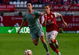 Loren Burón corre con el balón junto a Boñar.