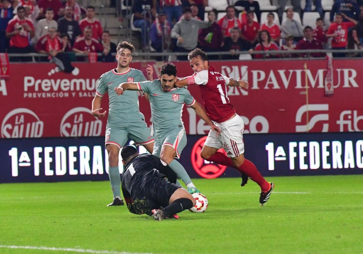 Pedro León, del Real Murcia, persigue un balón ante la salida de Iturbe, del Atlético B.