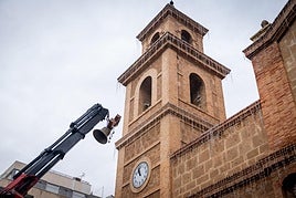 Elevan con una grúa una de las campanas hasta el campanario de la torre de Poniente del templo de la Inmaculada.