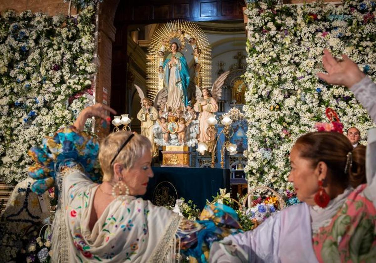 Dos mujeres bailan sevillanas frente a la imagen de la patrona de Torrevieja durante la ofrenda de flores del año pasado.