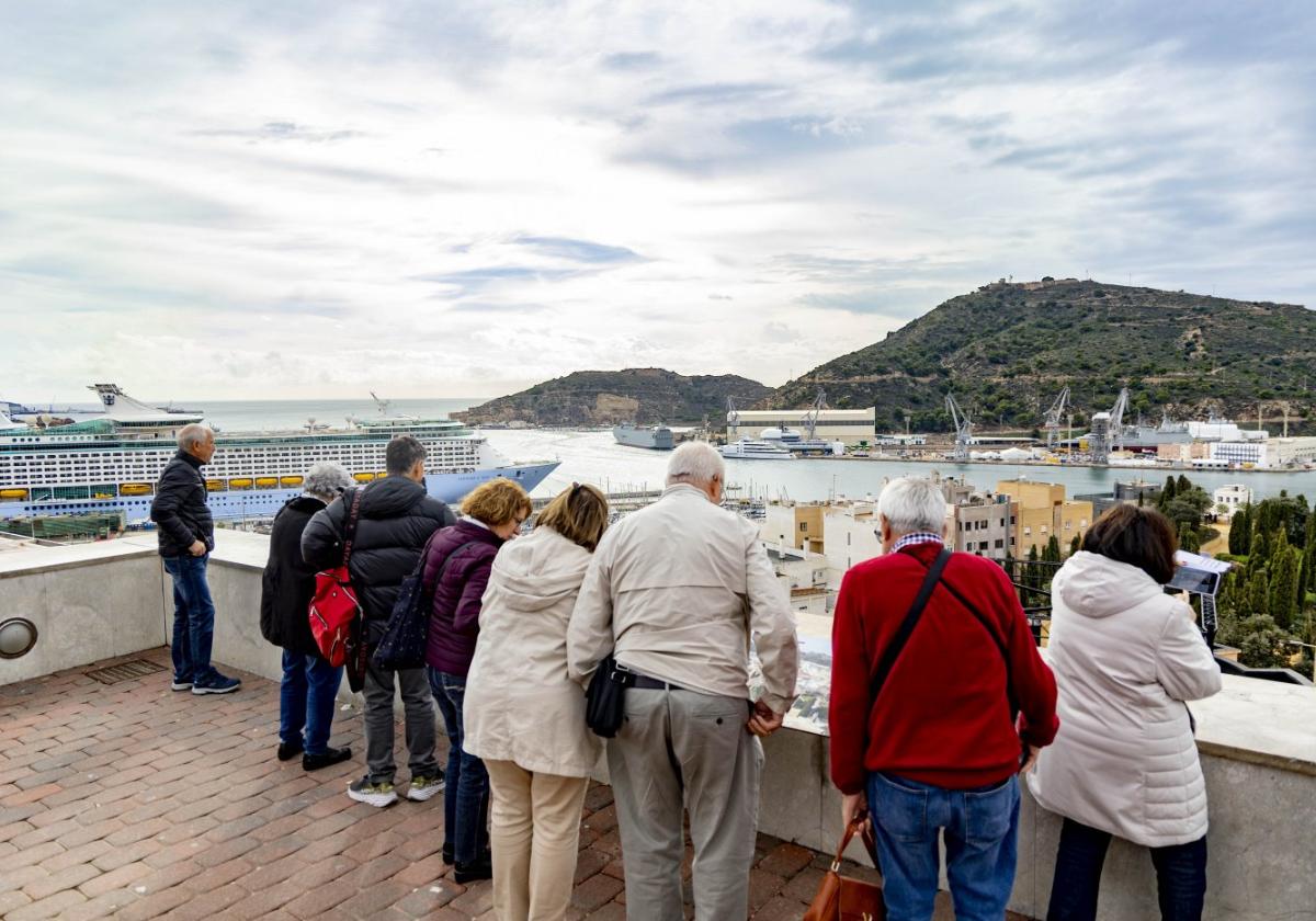 Turistas contemplan desde el Parque Torres las vistas del puerto; al fondo, el monte de la Podadera, con el cuartel de Fajardo en su soto; y a su derecha, sobre el astillero, el de Galeras rematado por su castillo.