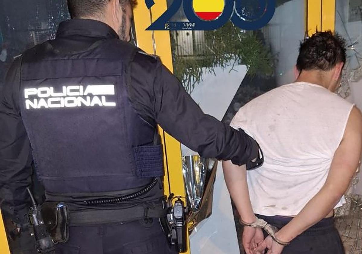 Un policía junto al detenido.