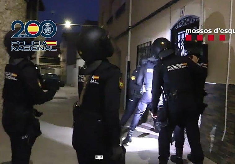 Los agentes tratan de derribar una puerta para proceder al registro de una vivienda.