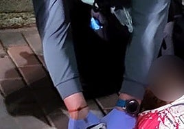 Un agente de la Guardia Civil le hace un torniquete en la muñeca al herido.