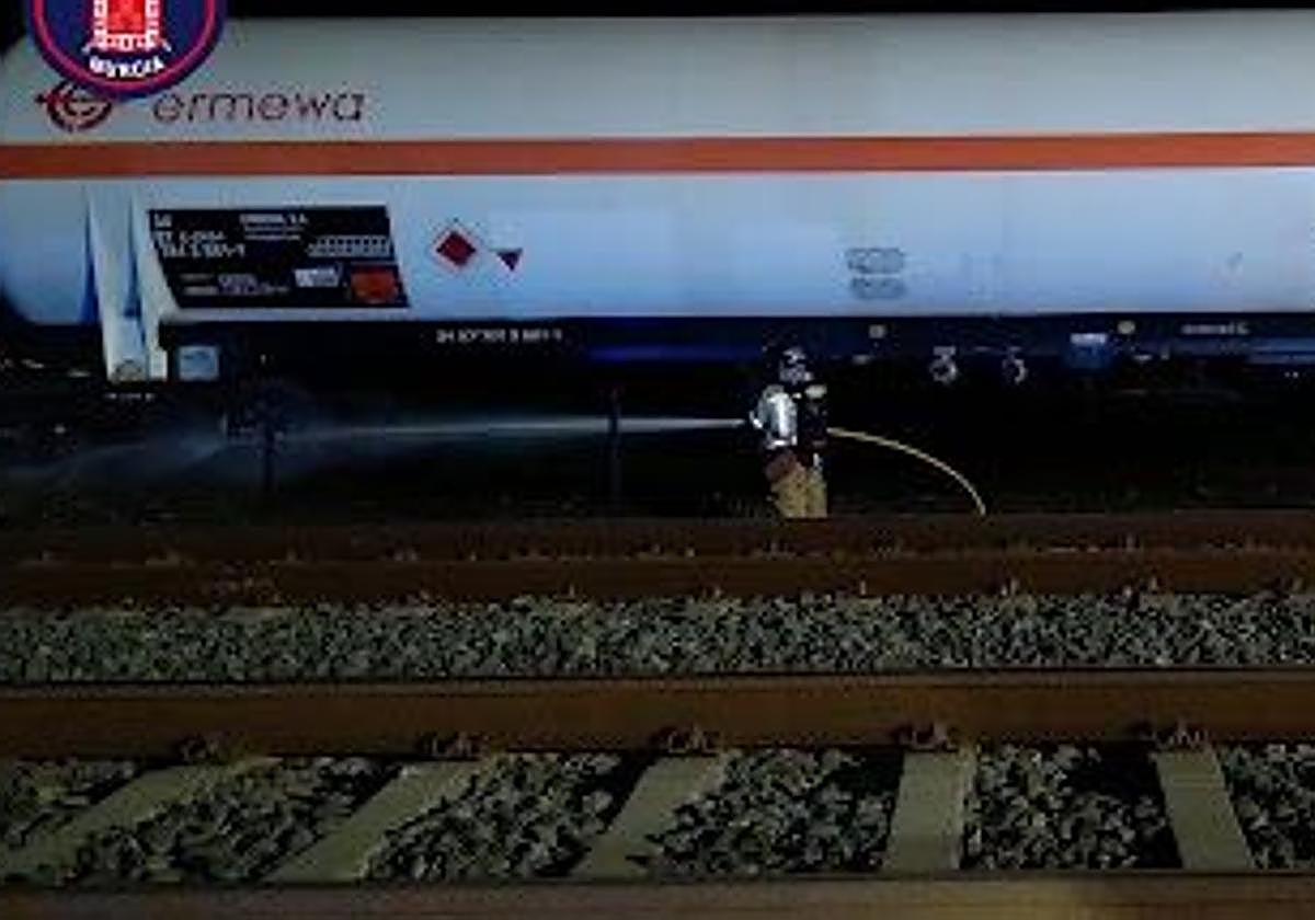 Un bombero extingue las llamas del vagón afectado del tren.