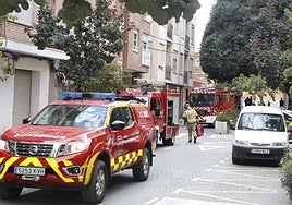 Bomberos, Policía Local y vecinos ante el edificio donde se originó el incendio.