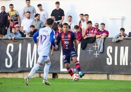 Mounir, jugador del Yeclano, controla el balón ante Cerrudo, del Recreativo de Huelva.