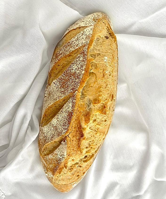 Imagen secundaria 2 - Rebanadas de pan y barras de masa madre. Una de las empanadillas que elaboran en Pan Moreno. Hogaza de pan artesanal.