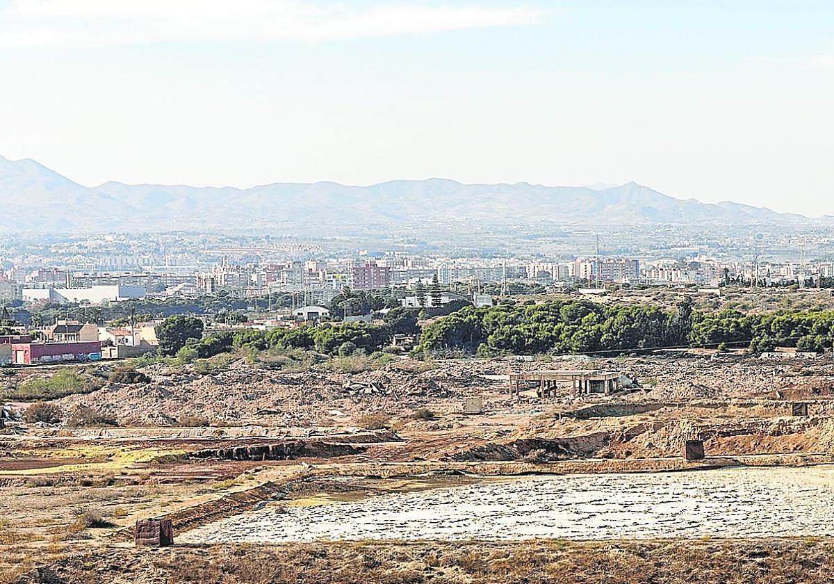 Balsas con residuos peligrosos a la intemperie en los suelos de la antigua Zinsa, junto a Torreciega. Al fondo, otras zonas de la ciudad de Cartagena, en diciembre de 2023.