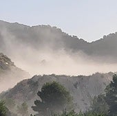 Polvareda en dispersión provocada por la planta de molienda de la Cantera 'Santa Rita VI', de Colina Cimar SL, que oculta las instalaciones.