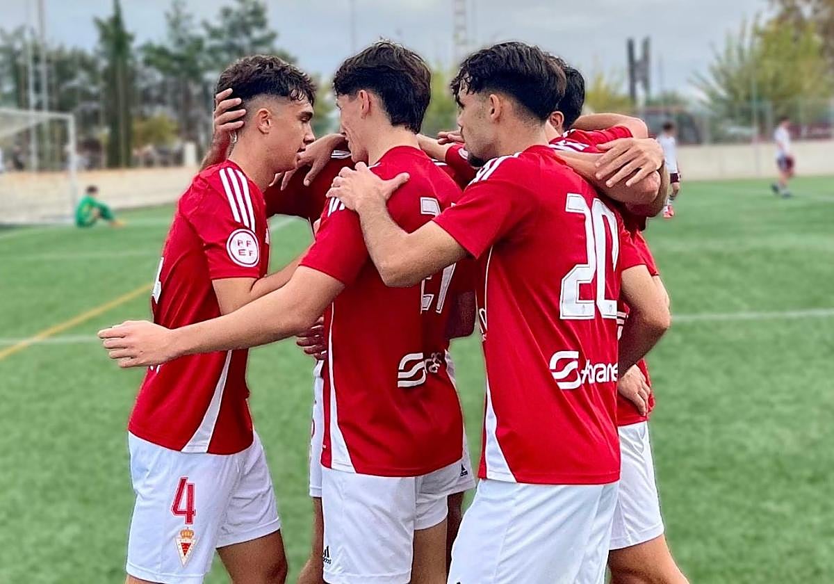 Los jugadores del Real Murcia juvenil se abrazan tras un gol.