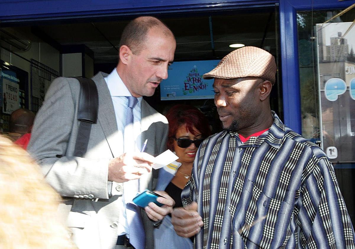 Uno de los premiados con el Gordo de la Lotería de Navidad es asesorado por un empleado de banca, en una imagen de archivo.