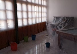 Estancia del casino afectada por la filtración, con parte del mobiliario original, como el piano de pared, cubierto con plásticos.