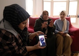 Mufide muestra un vídeo enviado por sus familiares en Siria, junto a su madre Iman y su hermana Amar.