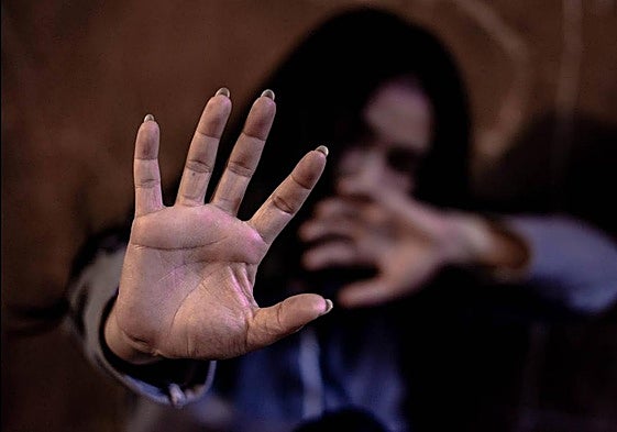 Imagen de archivo de una mujer tratando de protegerse.