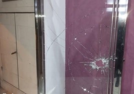 El cristal roto del portal del edificio asaltado en Cabezo de Torres.